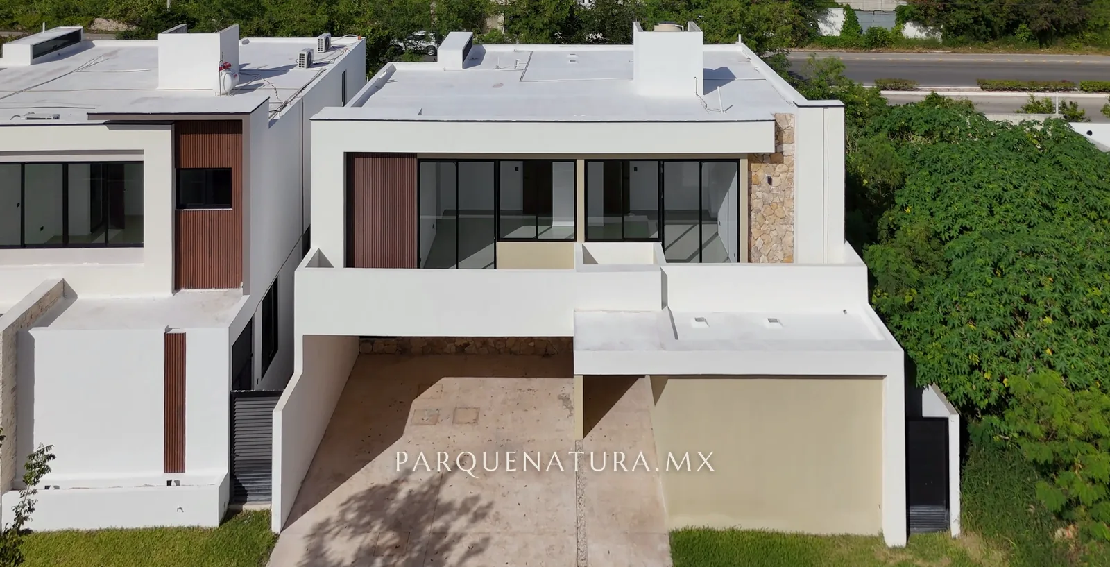 Fachada de la Casa 215-2 con duela de madera, ventanales y muro de piedra