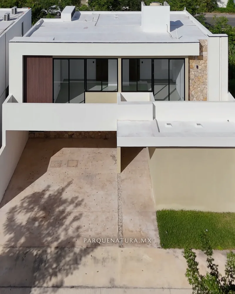 Fachada de la Casa 215-2 con duela de madera, ventanales y muro de piedra